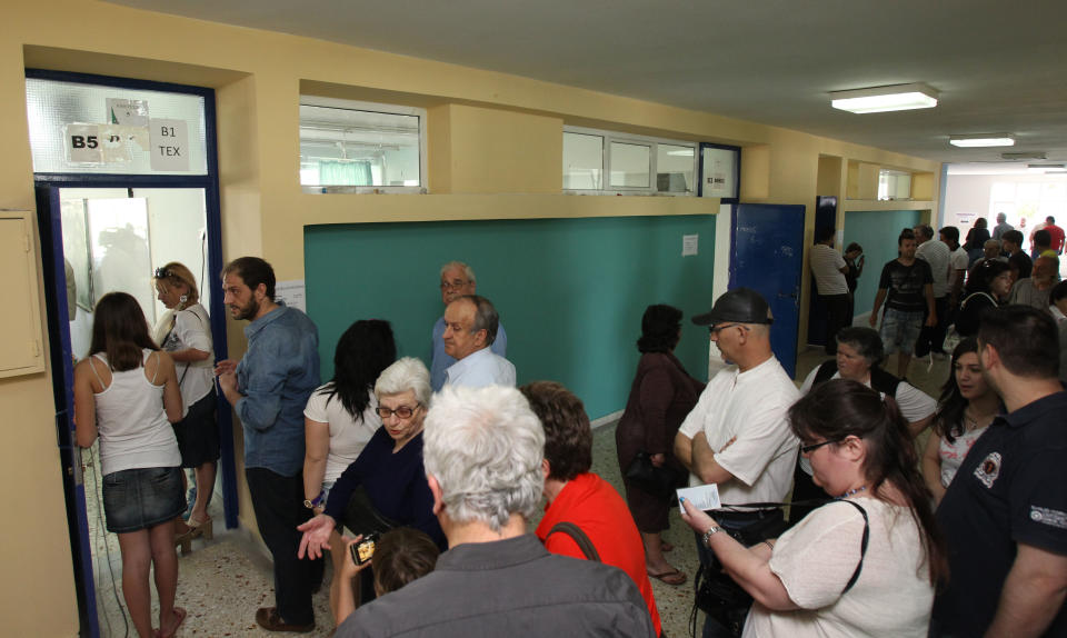 People wait in lines to vote at a polling station in Athens, Sunday, May 6, 2012, as the Greek people are keen to participate in the electoral process. Greeks cast their ballots on Sunday in their most critical and uncertain elections in decades, with voters seemingly set to punish the two main parties that are being held responsible for the country's dire economic straits. (AP Photo/Thanassis Stavrakis)