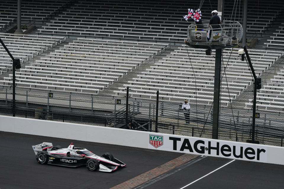 Josef Newgarden takes the checkered flag to win the IndyCar auto race at Indianapolis Motor Speedway in Indianapolis, Friday, Oct. 2, 2020. (AP Photo/Michael Conroy)
