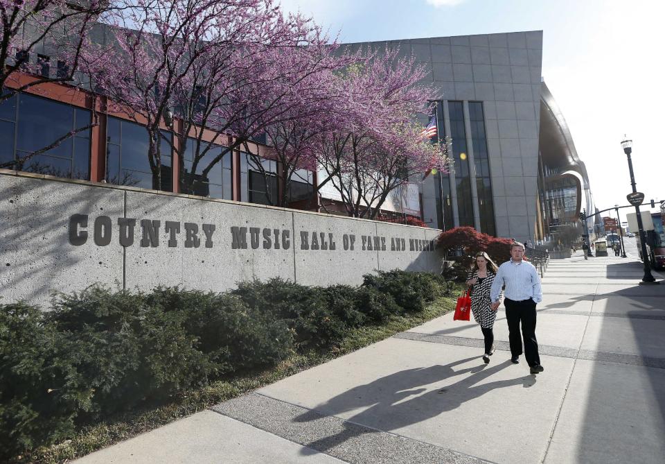 In this April 10, 2014, photo, people walk past the Country Music Hall of Fame and Museum in Nashville, Tenn. The facility is no longer bursting at the seams, thanks to a $100 million expansion that has more than doubled their space and allowed them to add more interactive and contemporary exhibits. (AP Photo/Mark Humphrey)