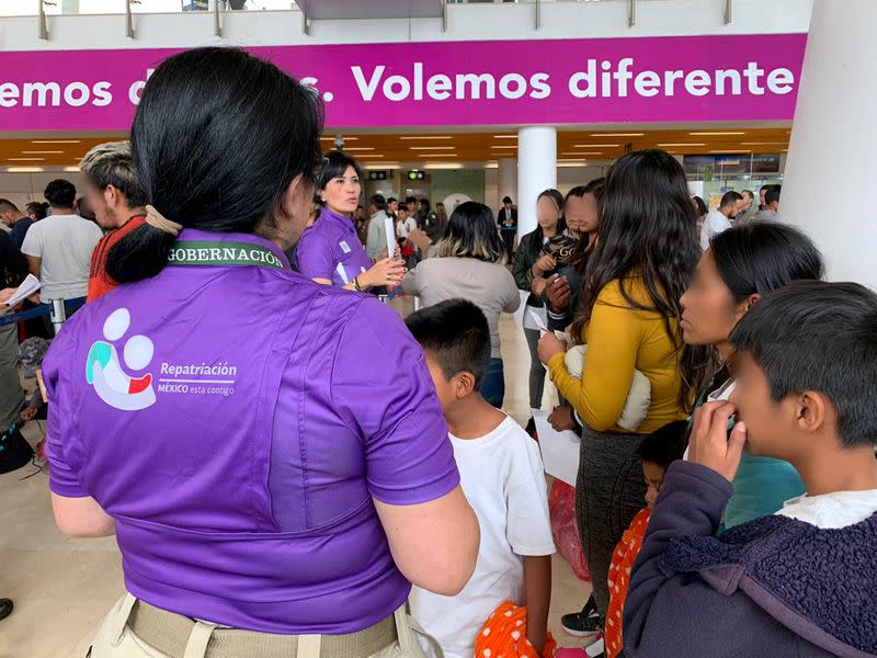 A government official talks to Mexican deportees after arriving on a flight from the U.S., at the Miguel Hidalgo y Costilla International airport in Guadalajara