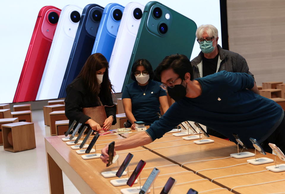 An employee arranges Apple iPhones as customer shop at the Apple Store on 5th Avenue shortly after new products went on sale in Manhattan, in New York City, New York, U.S., March 18, 2022. REUTERS/Mike Segar
