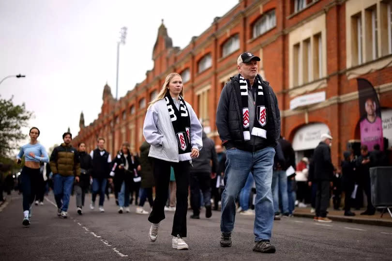 Fulham fans can be seen walking to the stadium prior to the Premier League match between Fulham FC and Crystal Palace at Craven Cottage on April 27, 2024 in London, England