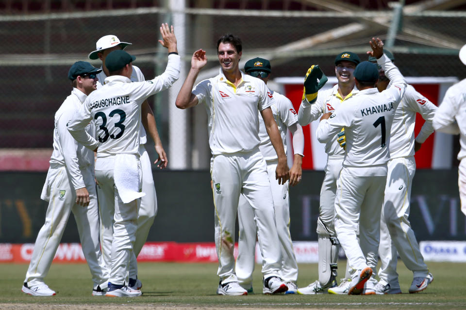 Australia's Pat Cummins, center, celebrates with teammates after the taking the wicket of Pakistan's Fawad Alam on the fifth day of the second test match between Pakistan and Australia at the National Stadium in Karachi Pakistan, Wednesday, March 16, 2022. (AP Photo/Anjum Naveed)
