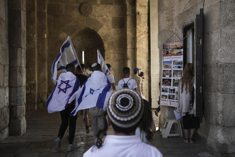 Israelis walk with national flags during a march marking Jerusalem Day, in Jerusalem's Old City, Thursday, May 18, 2023. The parade was marking Jerusalem Day, an Israeli holiday celebrating the capture of east Jerusalem in the 1967 Mideast war. Palestinians see the march as a provocation. (AP Photo/Maya Alleruzzo)