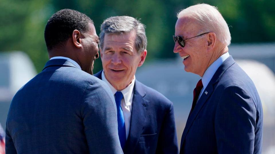 President Joe Biden talks with North Carolina Gov. Roy Cooper and EPA Administrator Michael Regan, after arriving at Raleigh-Durham International Airport, Raleigh, N.C., Thursday, June 24, 2021. Biden is in North Carolina to visit a mobile vaccination unit and meet with frontline workers and volunteers.