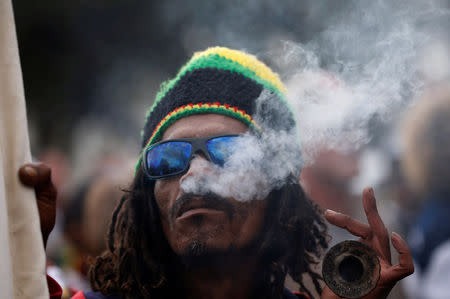 A man smokes marijuana, known locally as dagga, during a march calling for the legalisation of cannabis in Cape Town, South Africa, May 6, 2017. REUTERS/Mike Hutchings