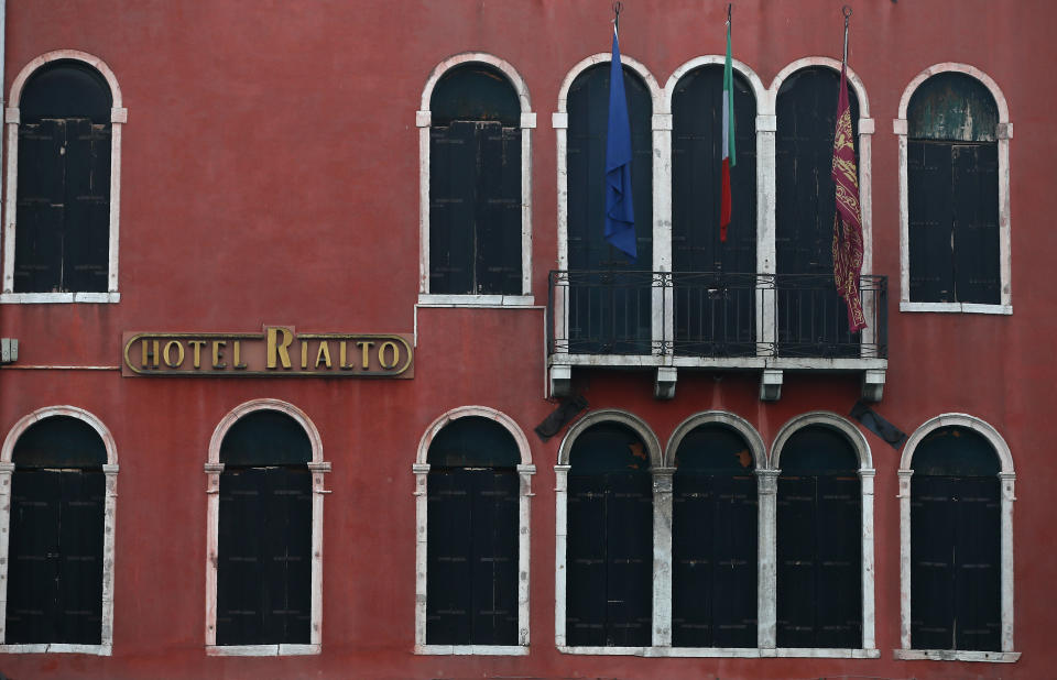 A view of a hotel with windows closed in Venice, Italy, Saturday, Jan. 30, 2021. Gondolas and other vessels are moored instead of preparing for Carnival's popular boat parade in the lagoon. Alleys are eerily empty. Venetians and the city's few visitors stroll must be masked in public places, indoors and out, under a nationwide mandate.(AP Photo/Antonio Calanni)