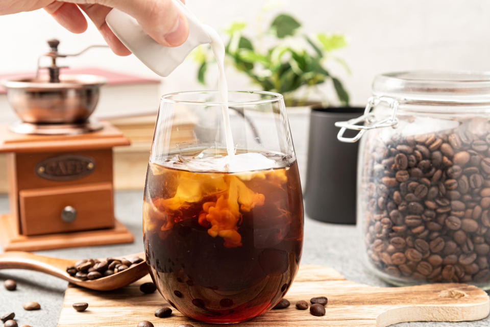 person pouring milk into their homemade cold brew