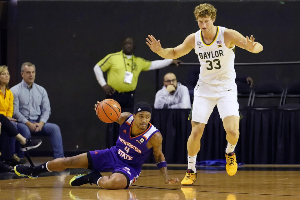 Northwestern State guard JaMonta' Black (4) looses his footing against Baylor forward Caleb Lohner (33) during the first half of an NCAA college basketball game in Waco, Texas, Tuesday, Dec. 20, 2022. (AP Photo/LM Otero)