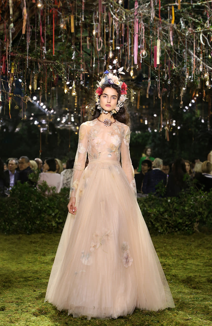 <p>The official description of this dress is “sand-colored pleated tulle dress with spring-themed herbal-inspired embroidery. Fête champêtre garland in silk flowers, raffia & bees.” If that is not poetry, then we don’t know what is! (Photo: Getty Images) </p>