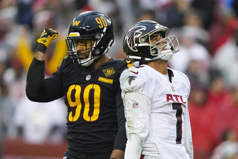 Atlanta Falcons quarterback Marcus Mariota (1) and Washington Commanders defensive end Montez Sweat (90) reacting to an interception thrown by Mariota during the second half of an NFL football game against the Washington Commanders, Sunday, Nov. 27, 2022, in Landover, Md. Washington won the 13-19. (AP Photo/Patrick Semansky)