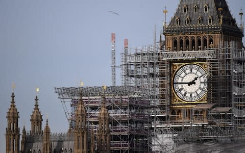 A bird flying in front of scaffolding around the Elizabeth Tower, commonly called Big Ben