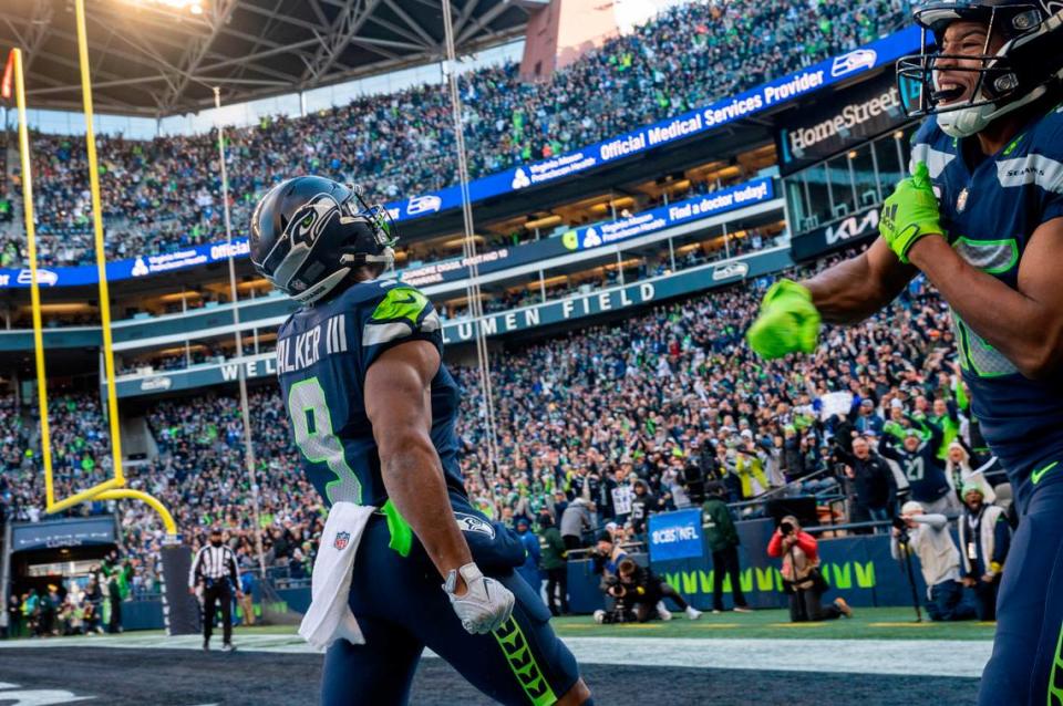 Seattle Seahawks running back Kenneth Walker III (9) and wide receiver Tyler Lockett (16) celebrate after Walker III’s touchdown in the first quarter of an NFL game on Sunday, Nov. 27, 2022, at Lumen Field in Seattle.