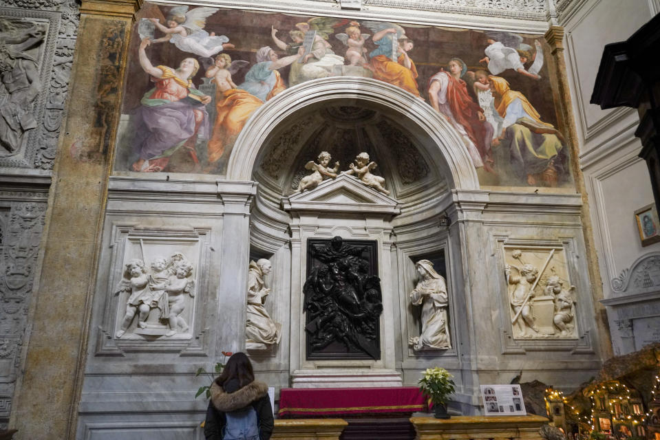 A woman admires the 1514 fresco "Sybils receiving instruction from Angels" by Italian High Renaissance master painter Raffaello Sanzio, known as Raphael, adorns the inside of Santa Maria della Pace church, in Rome, Monday, Dec. 14, 2020. Like elsewhere in Europe, museums and art galleries in Italy were closed this fall to contain the spread of COVID-19, meaning art lovers must rely on virtual tours to catch a glimpse of the treasures held by famous institutions such as the Uffizi in Florence and the Vatican Museums in Rome. However, some exquisite gems of Italy's cultural heritage remain on display in real life inside the country's churches, some of which have collections of renaissance art and iconography that would be the envy of any museum. (AP Photo/Andrew Medichini)