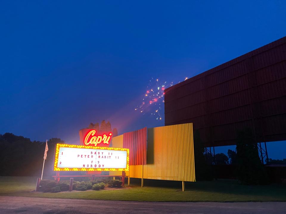 Fireworks are seen in the background with the marquee sign lit at night at Capri Drive-In Theater in Coldwater.
