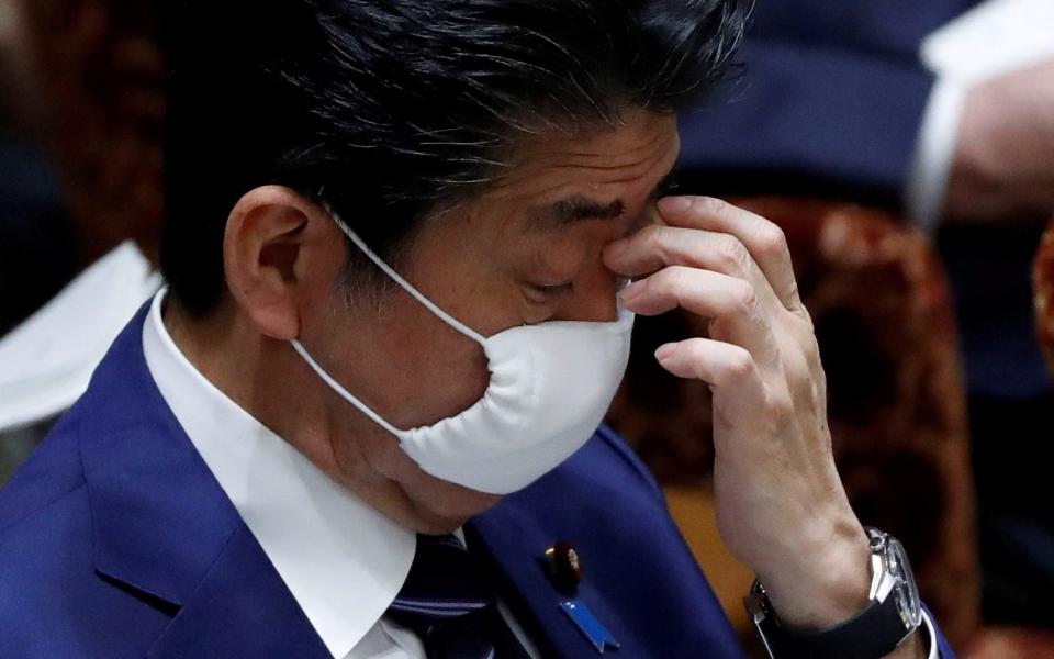 Japan's Prime Minister Shinzo Abe wears a protective face mask as he attends an upper house parliamentary session - Reuters