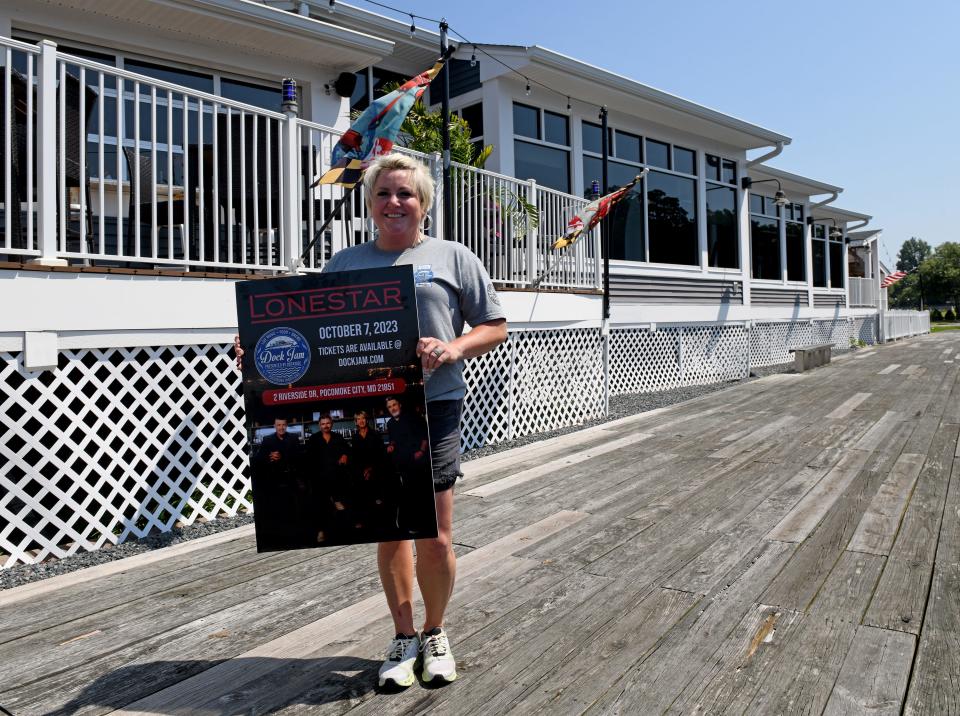 Caitlin Evans, owner of Dockside, holds the poster board for the next Dock Jam Thursday, July 27, 2023, in Pocomoke City, Maryland. The October 7 Dock Jam will feature Lonestar with a new opening act.