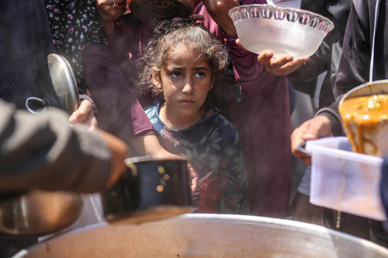 Displaced Palestinians wait to receive cooked food rations at a donation point in Deir al-Balah, in the central Gaza Strip, April 16, 2024. / Credit: Majdi Fathi/NurPhoto/Getty