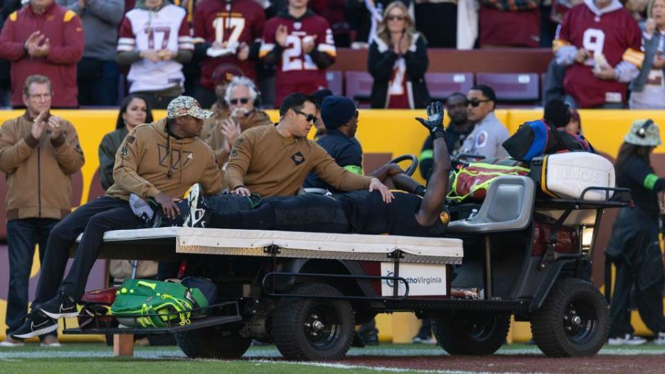 Efe Obada is carted from the field after getting injured while playing for the Washington Commanders against the New York Giants