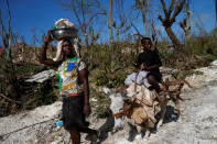 <p>A woman and a child riding a donkey pass by destroyed houses after Hurricane Matthew hit Jeremie, Haiti, October 7, 2016. (REUTERS/Carlos Garcia Rawlins)</p>