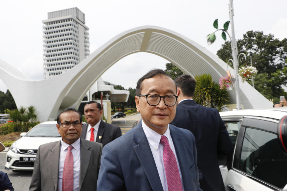 Cambodia's exiled opposition leader Sam Rainsy is asked for comments outside Parliament House in Kuala Lumpur, Malaysia, Tuesday, Nov. 12, 2019. Rainsy landed in Kuala Lumpur in a bid to return to his homeland after Thailand had earlier blocked him from entering. (AP Photo/Vincent Thian)