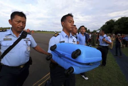 Air force personnel carry presumed to be from missing Indonesia Air Asia flight QZ 8501recovered from the sea at Pangkalan Bun, Central Kalimantan, December 30, 2014 in this photo taken by Antara Foto. REUTERS/Antara Foto/Kenarel