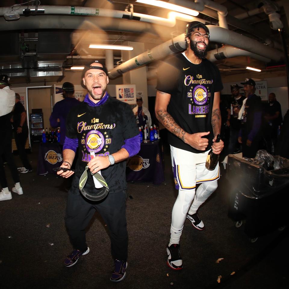 Former Michigan State basketball team manager Andrew Henk, left, celebrates with Anthony Davis in the locker room after the Los Angeles Lakers beat the Miami Heat for the NBA title on Oct. 11 in Orlando, Florida. Henk, a 29-year-old from Shelby Township, is the first-year equipment manager for the Lakers.