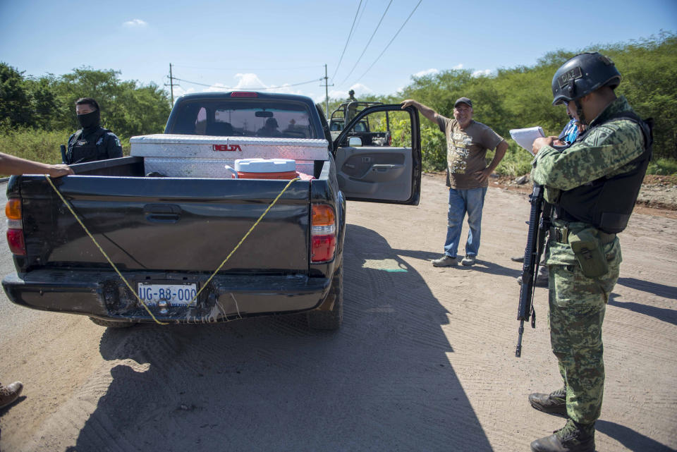 A Mexican soldier mans a checkpoint on the road to the municipality of Novalto, near Culiacan Mexico, Saturday, Oct. 26, 2019. Six 24/7 checkpoints have been set up on the main entrances to the city of Culiacan, to search for weapons or contraband. (AP Photo/Augusto Zurita)