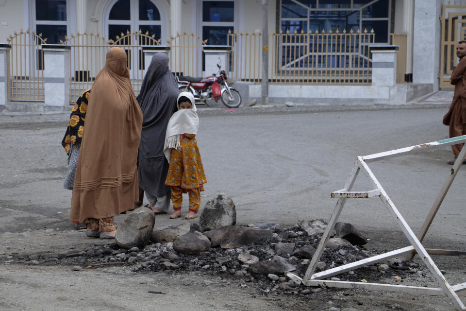 Women and children look at a spot where a Muslim mob lynched and burned a man over allegations that he had desecrated Islam's holy book, the Quran, in Madyan in Pakistan's Khyber Pakhtunkhwa province, Friday, June 21, 2024. The attackers also torched a police station which had held the man in Madyan and burned police vehicles parked there, according to local police official Rahim Ullah. (AP Photo/Naveed Ali)