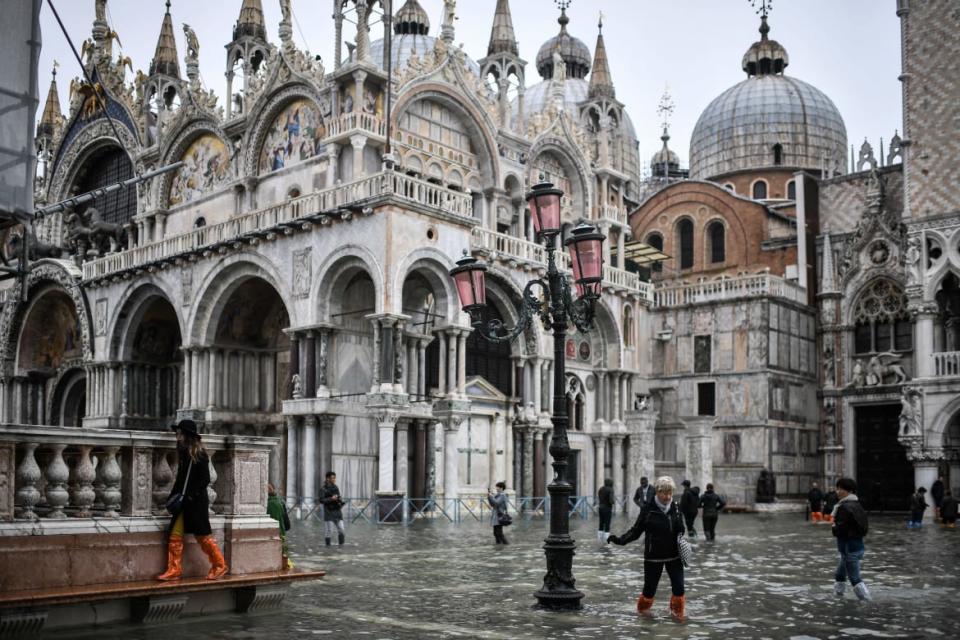 <div class="inline-image__caption"><p>Pedestrians were forced to walk on raised sidewalks to navigate the flooded square in front of St. Mark’s Basilica. The central square floods almost 100 times a year, but water rarely escapes into the rest of the city. </p></div> <div class="inline-image__credit">Marco Bertorello/Getty</div>