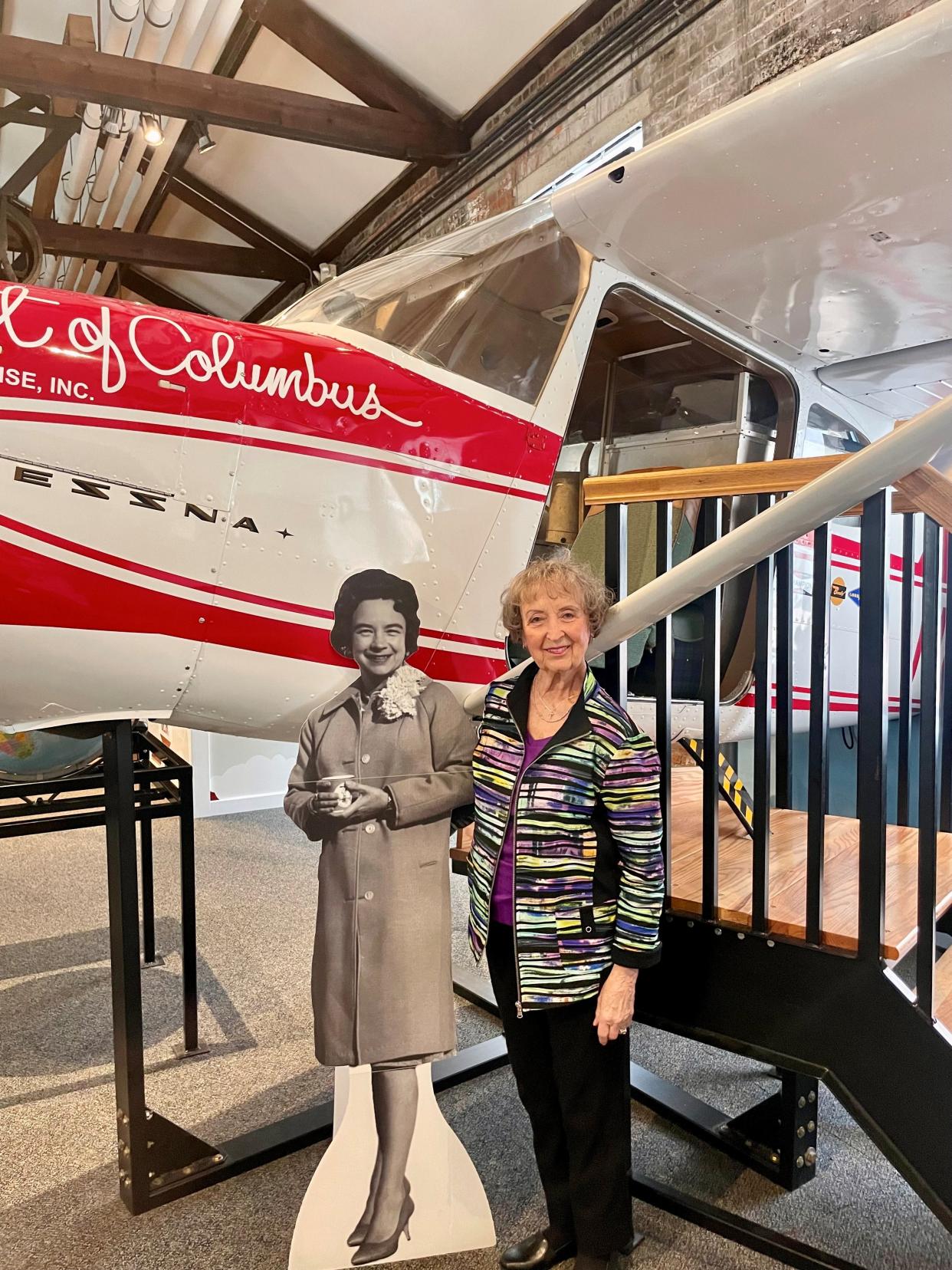 Susan Reid stands with a cutout of her sister, Jerrie Mock, and a model of Mock's plane at The Works. Mock, a Newark native, was the first woman to fly around the world.