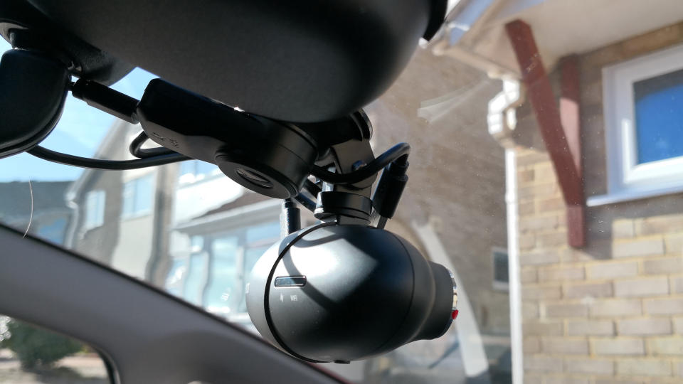 A dash cam mounted inside a car windscreen