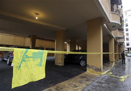 A Hezbollah flag is seen near the crime scene where commander Hasan al-Laqqis was killed in the southern Hadath district in Beirut December 4, 2013. REUTERS/Hasan Shaaban