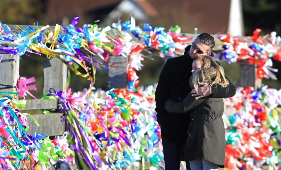 Friends of one of the victims Matt Jones look at tributes to those who died in the disaster (PA)