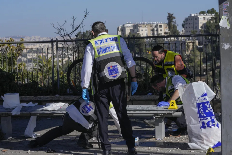 Members of Zaka Rescue and Recovery team clean blood from the scene of an explosion at a bus stop in Jerusalem.