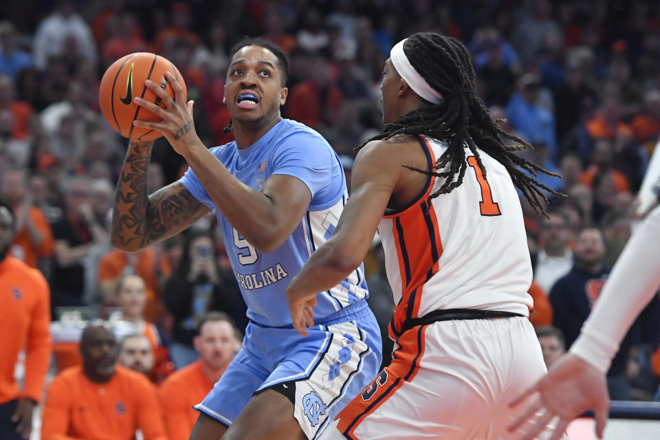 North Carolina forward/center Armando Bacot, left, is defended by Syracuse forward Maliq Brown during the first half of an NCAA college basketball game in Syracuse, N.Y., Tuesday, Feb. 13, 2024. (AP Photo/Adrian Kraus)