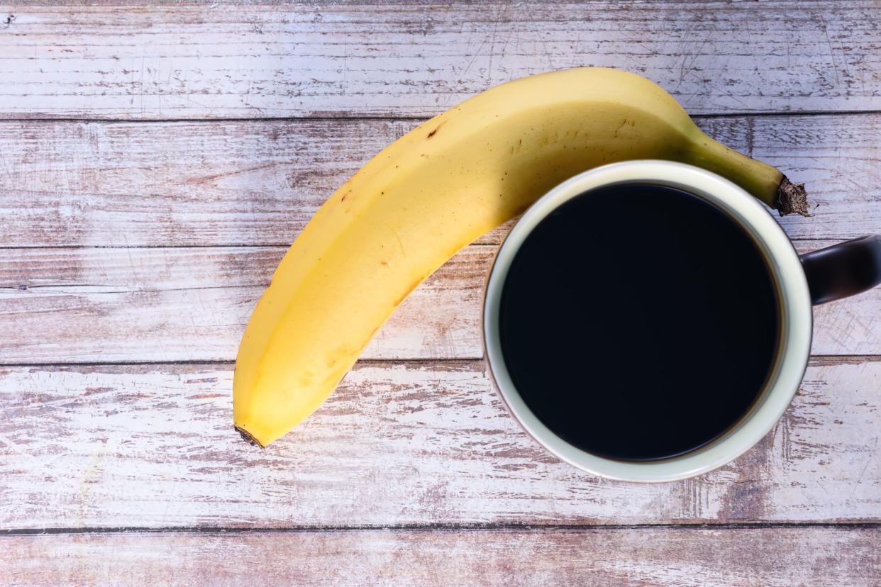 Coffee and banana on wood table textured background with room for copy text