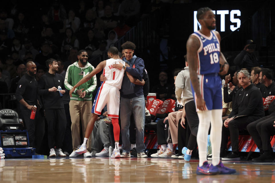 The Brooklyn Nets bench embraces forward Mikal Bridges (1) as Philadelphia 76ers guard Shake Milton (18) looks on during the first half of an NBA basketball game, Sunday, April 9, 2023 in New York. (AP Photo/Jessie Alcheh)