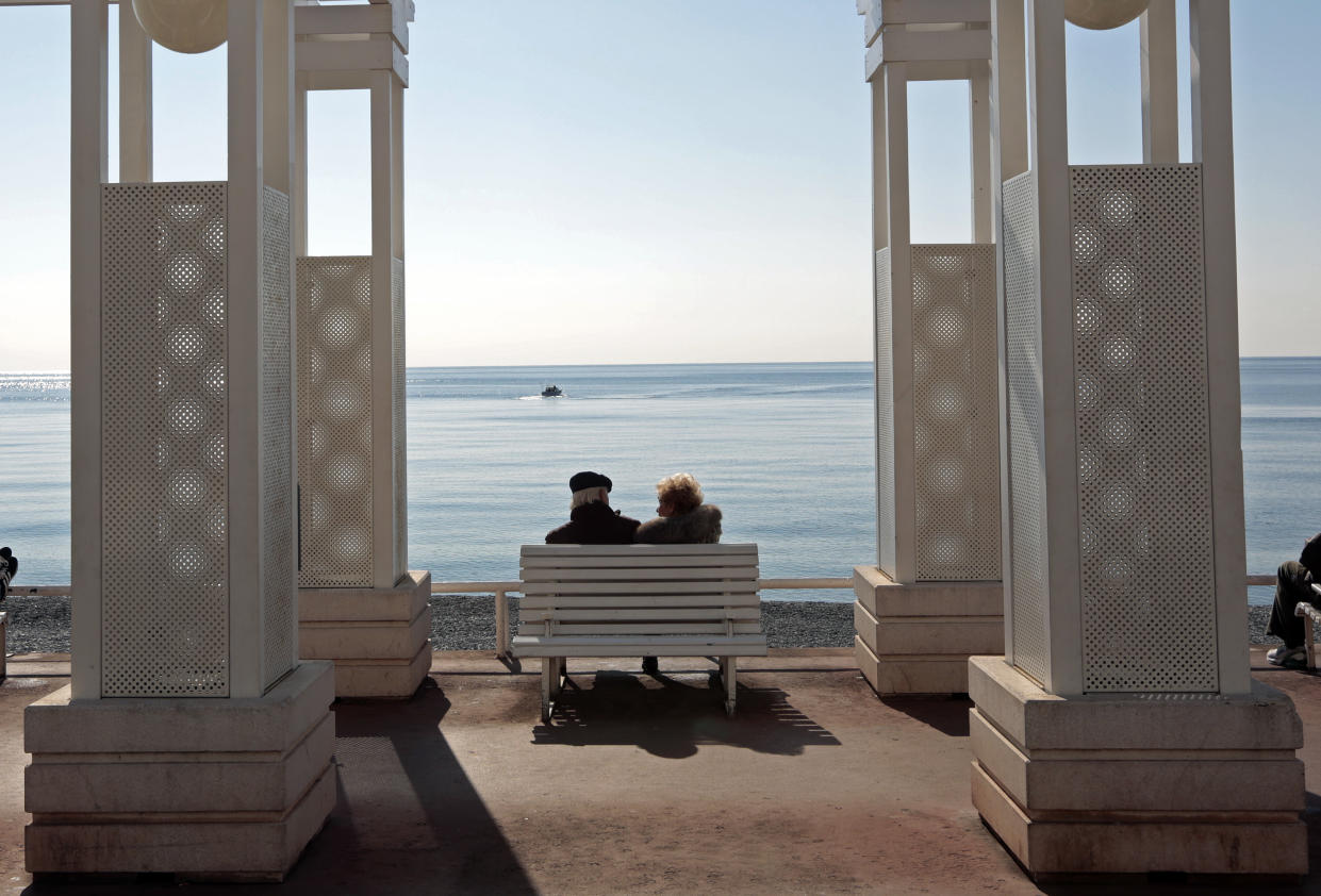 Elderly people sit on a bench in Nice, France