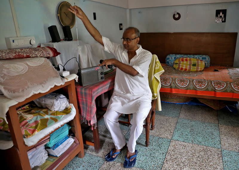 Nikhil Kumar Mondal adjusts the antenna of his radio inside his house on the outskirts of Kolkata