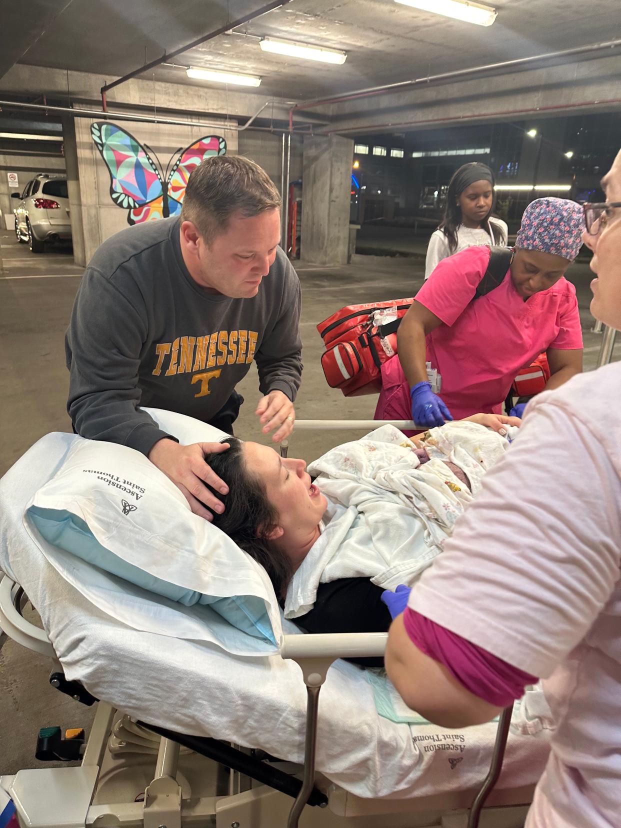 Josh Thomas comforts his wife Jena after their son Jackson (in the blanket on her chest) was born in a parking garage.