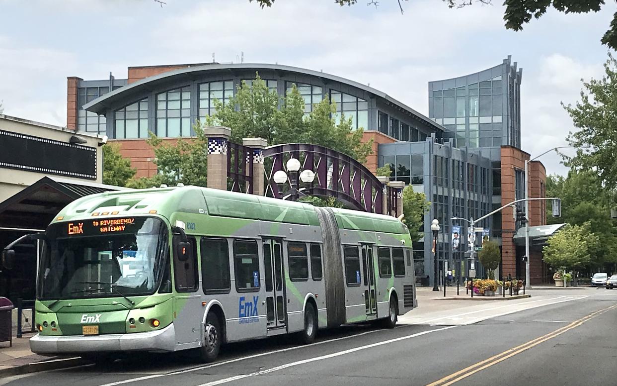 A Lane Transit District EmX bus waits outside the downtown Eugene Public Library.