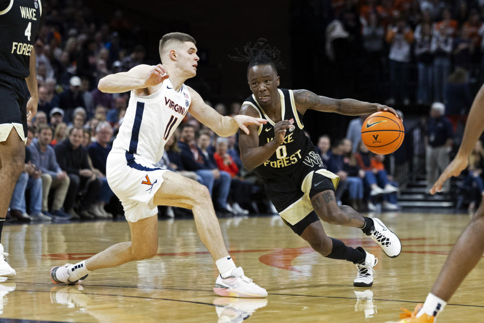 Wake Forest's Kevin Miller (0) drives with the ball as Virginia's Isaac McKneely (11) defends during the first half of an NCAA college basketball game Saturday, Feb. 17, 2024 in Charlottesville, Va. (AP Photo/Mike Kropf)
