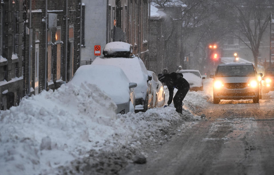 A man shovels his car out of a street parking space, as a major storm hits eastern Canada on Friday, Dec. 23, 2022 in Quebec City. (Jacques Boissinot/The Canadian Press via AP)