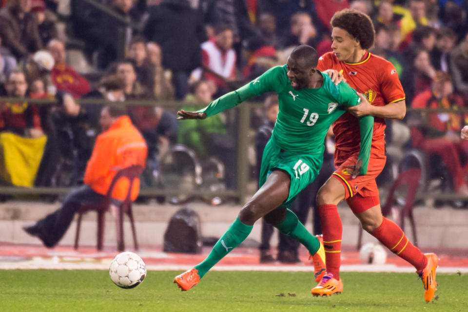 FILE - In this March 5, 2014, file photo, Belgium's Axel Witsel, right, challenges Ivory Coast's Yaya Toure during a friendly soccer match at the King Baudouin stadium in Brussels. The Elephants had a comfortable qualification run under French coach Sabri Lamouchi, with a team filled with Europe-based talent including Manchester City's Yaya Toure. (AP Photo/Geert Vanden Wijngaert,File)