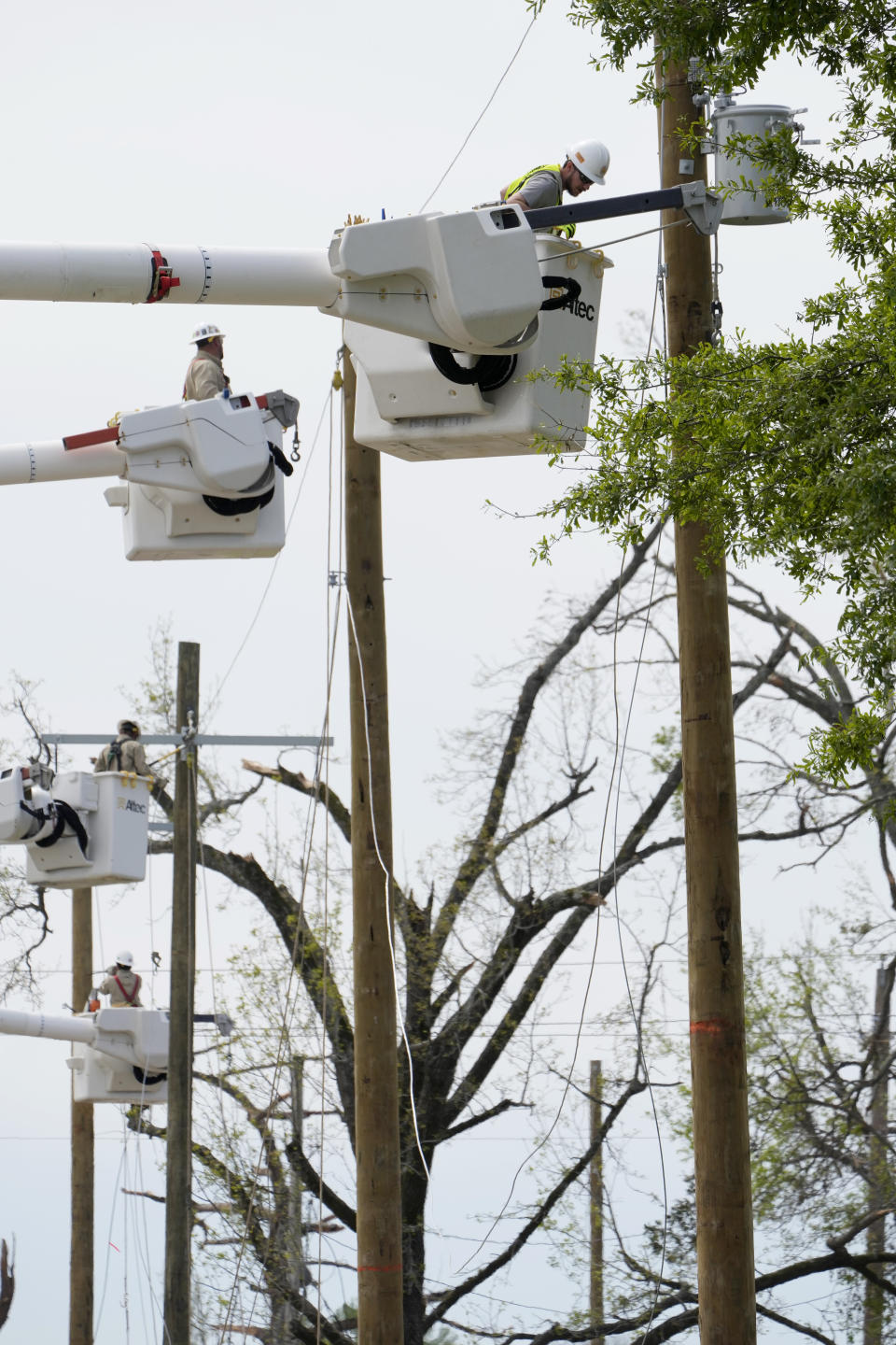 Utility linemen string cables on new light poles during recovery from the March 24 killer tornado that rolled through Rolling Fork, Miss., on March 29, 2023. Many area residents are hopeful the county seat will be rebuilt with improvements to the city's infrastructure. (AP Photo/Rogelio V. Solis)