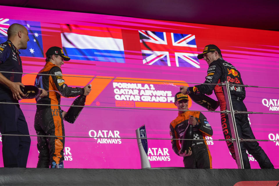 Red Bull driver Max Verstappen of the Netherlands, right, sprays champagne on the podium after winning the Qatar Formula One Grand Prix auto race at the Lusail International Circuit, in Lusail, Qatar, Sunday, Oct. 8, 2023. (AP Photo/Darko Bandic)