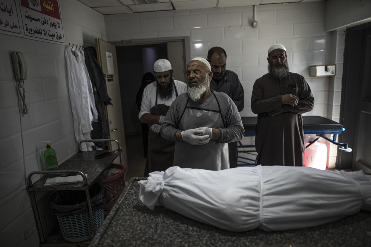 The body of Palestinian Muhammad Hassouna, who was killed in an Israeli airstrike is prepared for his funeral at a hospital in Rafah, in the southern Gaza Strip, Sunday, Aug. 7, 2022. An Israeli airstrike in Rafah killed a senior commander in the Palestinian militant group Islamic Jihad, authorities said Sunday, its second leader to be slain amid an escalating cross-border conflict. (AP Photo/Fatima Shbair)