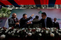 FILE PHOTO - Nadeem Naqvi (L), Managing Director of the Pakistan Stock Exchange, shakes hands with Chinese officials after signing an agreement for a Chinese-led consortium to buy a strategic stake in PSX in Karachi, Pakistan, January 20, 2017. REUTERS/Akhtar Soomro/File Photo