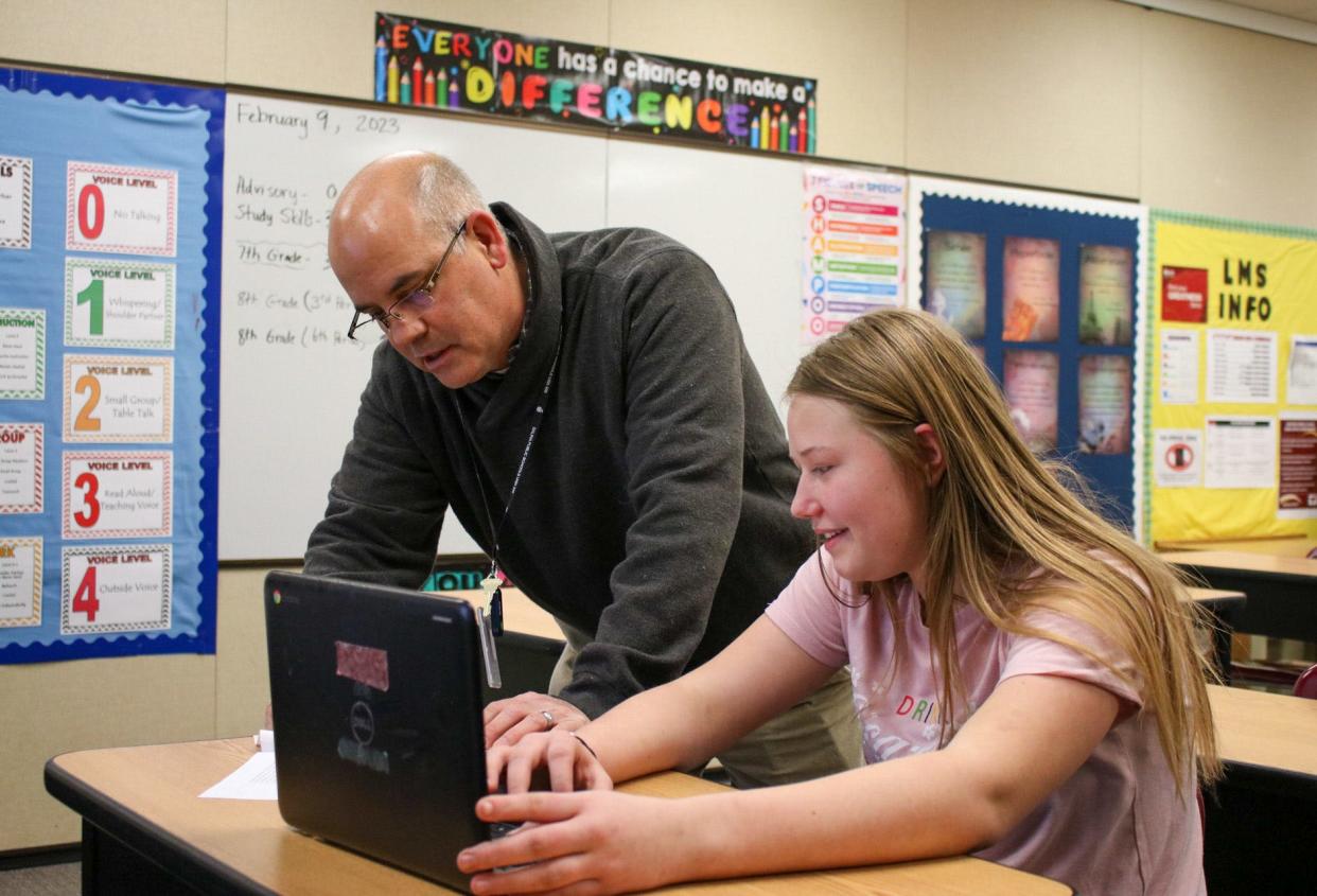 Dan Finnegan discusses an assignment with Kimberly Grawberg, an eighth grade student at Lakewood Middle School in Salina. Out-of-state transfers like Finnegan could soon have an easier path to teacher licensure following Kansas' entry into the Interstate Teacher Mobility Compact.
